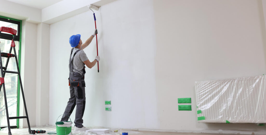 A painter painting a wall in an office